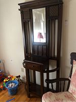 Full front view of wooden hall tree showing mirror, drawer and shelf
