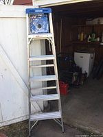 Full view of 6ft Werner aluminum ladder with paint marks and worn condition