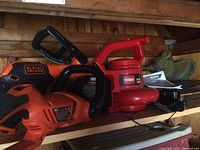 Toro electric leaf blower model 51586 red and Black & Decker power tools on shelf