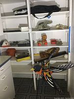 Shelves with various items including baseball gloves, bats, basketball, Oriole yard decoration, and toys