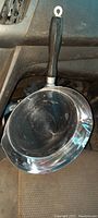 Side view of the 9-inch nickel-plated pan showing the handle and the inside cooking surface with visible wear.