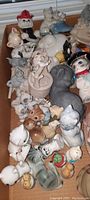 Floor view of a large assortment of ceramic cat figurines tightly packed together, showing a variety of colors and poses.