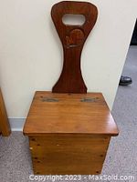 Front view of wooden box showing hinged lid and carved whale on tall back handle.
