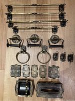 Full display photo showing all metal fixtures including towel racks, hooks, outlet covers, soap dish, and tissue box holder laid out on floor.