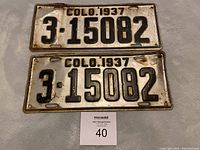 Front view of two 1937 Colorado metal license plates with embossed black number 3-15082 on white background.