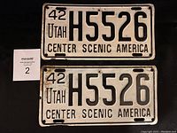Front view of two 1942 Utah license plates, showing plate number H5526 and slogan 'CENTER SCENIC AMERICA'. Plates show wear and scuffs.
