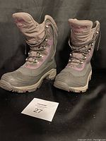 Front view of the pair of dark grey and purple Columbia women's winter boots with grip soles, showing overall condition and design.