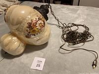 Full view of hanging swag lamp showing iridescent glass with floral design and attached chain and plug