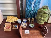 Overview of all items including Buddha head, bookends, cups, and other decor pieces.
