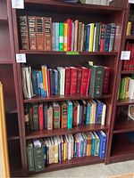 Full view of the wooden bookshelf filled with books on multiple shelves.