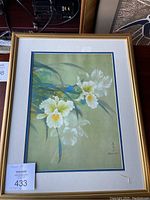 Framed artwork showing white flowers with yellow centers and green leaves on a green background, signed by David Lee.