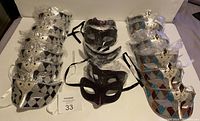 Sets of Harlequin Venetian style masquerade masks arranged in three groups by color pattern: 5 silver-black, 5 burgundy glitter with designs, and 2 brown blue red diamond pattern masks. All have ribbons tied for wearing.