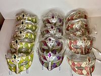 14 new masquerade masks in green/gold, purple/silver, and red/gold harlequin diamond patterns wrapped individually in plastic.