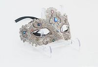 Silver lace masquerade mask with jewels on display