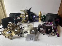 View of all ten masquerade and costume masks arranged on a white surface showing various styles including long nose, Venetian, feathers, and colorful Mardi Gras themed designs.