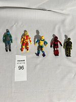 Five G.I. Joe action figures lined up on a white fabric background with a lot number card