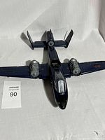 Top down view of the 1984 Cobra Rattler GI Joe toy plane airplane in dark blue with twin under-wing engines and single rear engine, cockpit canopy and cockpit area visible.