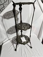 Full view of brass three-tier plant stand on white background