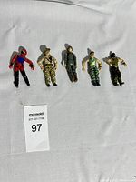 Five G.I. Joe action figures laid flat on a white background, showing full group.