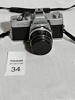 Front view of the Minolta SR-T 200 camera with lens and strap, showing the overall condition and presence of lens cap.