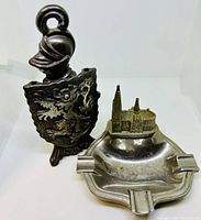 Cast iron bottle opener and metal ashtray displayed together showing details and size