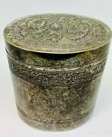 Oval silver plated trinket box with raised floral and scroll repousse design on lid and body band, showing tarnishing and wear on surface