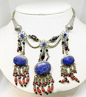 Front view of the Tibetan silver choker necklace shown on display bust featuring three large lapis lazuli stones and coral bead tassels.