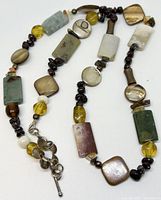 Close-up view of the necklace showing the diverse shapes and colors of the beads along with the silver toggle clasp.