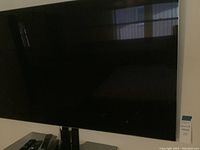 Front view of black Samsung flat-screen television showing reflective screen and stand
