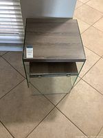 Top view of a nesting table showing wood grain tabletop and glass sides