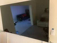 Front view of Samsung flat screen TV reflecting room interior, showing screen condition and size.