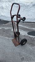 Full view of the heavy duty dolly showing metal frame, handle, platform, and tires.