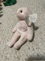 Pink Ty Beanie Baby Hoppity plush sitting upright on a carpeted floor with its Ty heart tag attached.