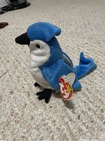Front-side view of the Rocket Beanie Baby showcasing blue, white, and black coloring and attached original Ty heart tag.