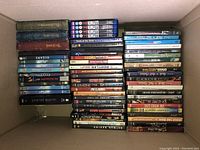 Photo showing three stacks of DVDs including titles such as Planet Earth, The Lord of the Rings, The Da Vinci Code, Looper,and others.