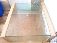 Full view of the living room table showing glass top and wooden frame.