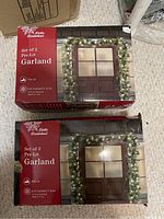 Photo of two boxed sets of Winter Wonderland pre-lit garland, showing product packaging and branding.
