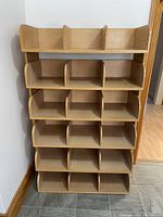 Front view of the wooden shelf with five rows and three columns of compartment slots for sorting or storage.