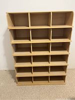 Full front view of the wooden shelving unit showing 16 compartments in a 4x4 layout.