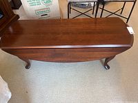 Top view of wooden coffee table with both drop leaves down, showing dark wood finish and cabriole legs.