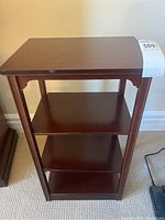 Front view of wooden end table with three lower shelves showing overall condition.