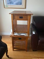Two stacked wood end tables showing natural wood finish and metal drawer handles.