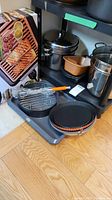 Photo showing Gotham Steel electric grill box and multiple cookware items including pots, meatloaf tray, pie pan, cookie sheet
