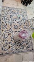 Floral patterned area rug with rolled striped runner on top