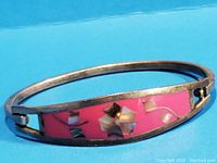 Close-up view of vintage Mexico Alpaca bracelet bangle showing pink enamel with inlaid abalone shell pieces and silver-tone metal band.