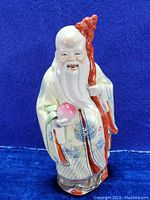 Front view of the Shou deity statue showing details of face, staff, peach, and robe patterns.