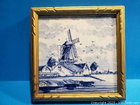 Full view of the framed tile showing the windmill scene and gold wooden frame