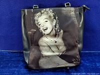 Front view of vintage handbag featuring a black and white printed image of Marilyn Monroe with rhinestone embellishments on necklace and earrings.