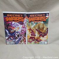 Both Secret Wars comic books, issues #7 and #8, upright against a wall showing front covers.