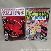 Photo of two comic books: Scarlet Spider #7 and Peter Parker #80, both bagged and boarded.